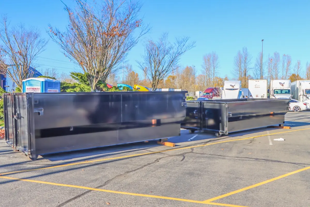 Professional dumpster rental service with roll-off container on residential driveway in Littlefield